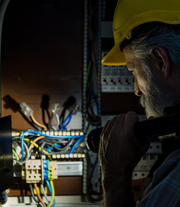 Man in the dark looking at the electrical system 
